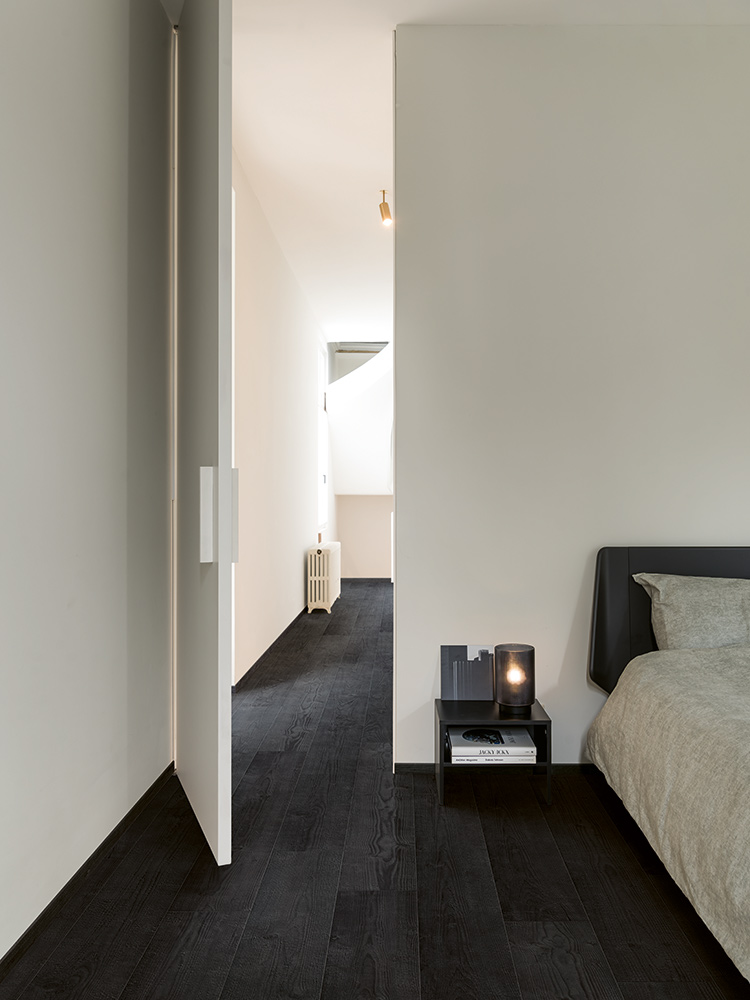 Black laminate flooring in white bedroom